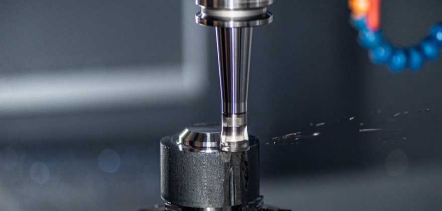 Precision component held in a lathe chuck while a spindle tool cuts it under coolant